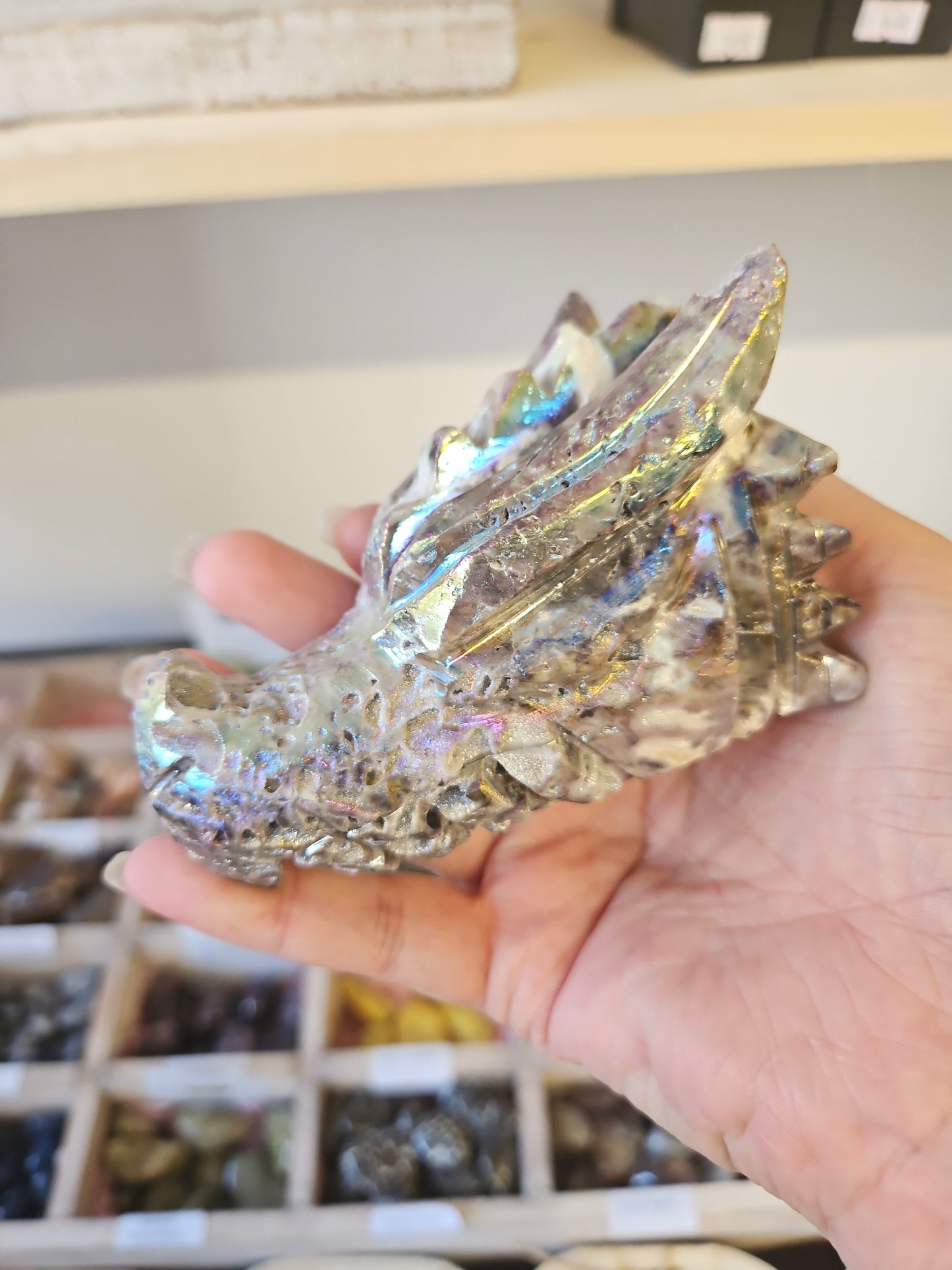 Crystal dragon figurine held in a hand with a blurred background