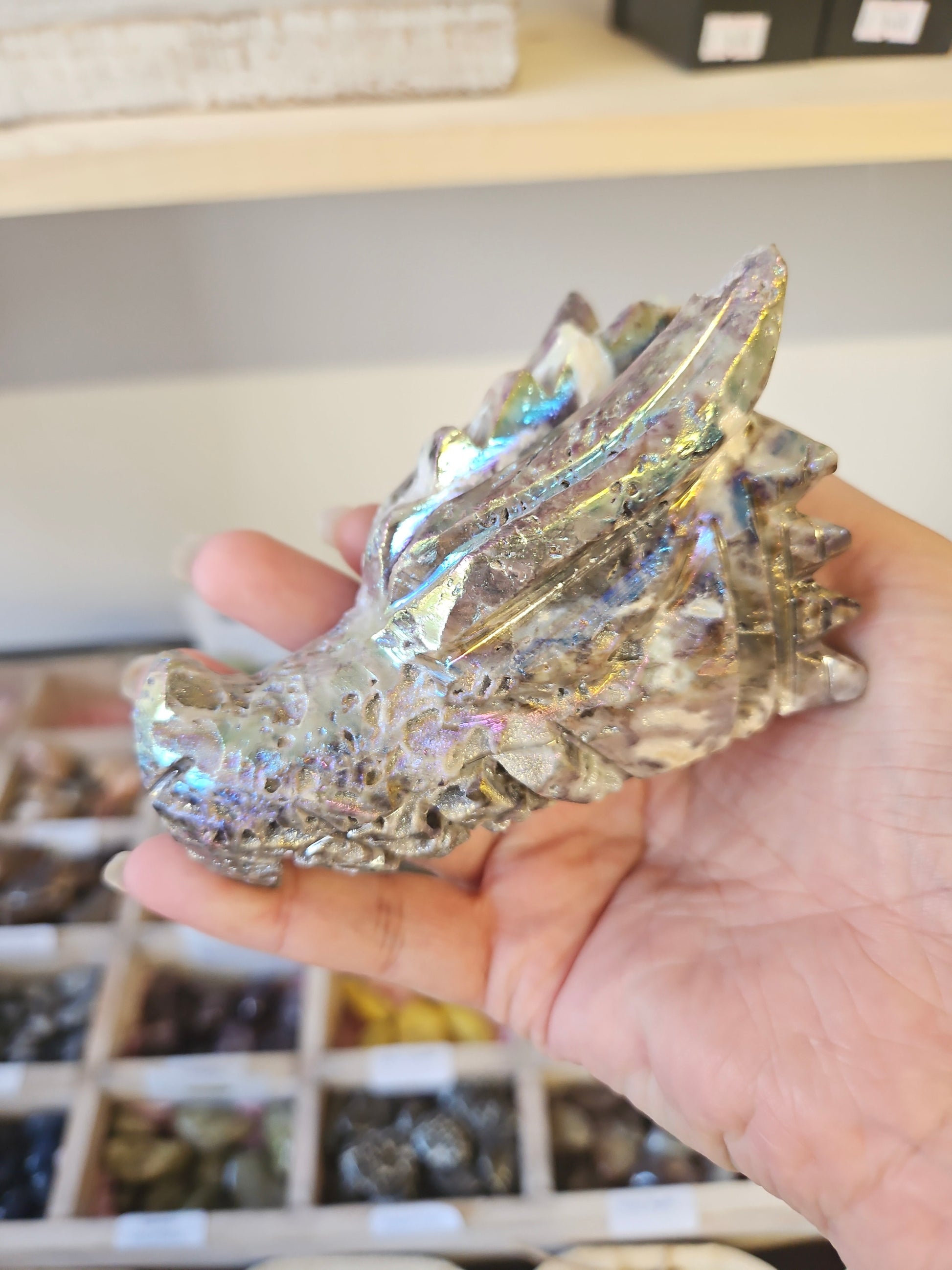 Crystal dragon figurine held in a hand with a blurred background