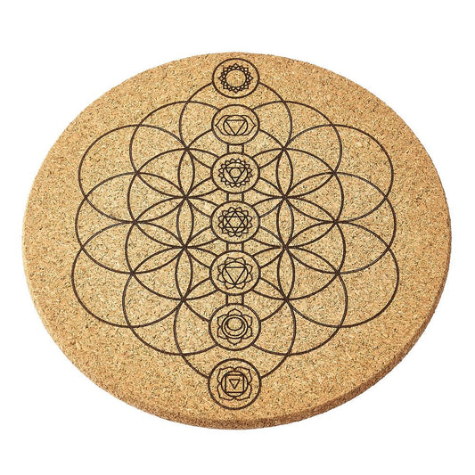 Round cork crystal grid with chakra symbol design on a white background