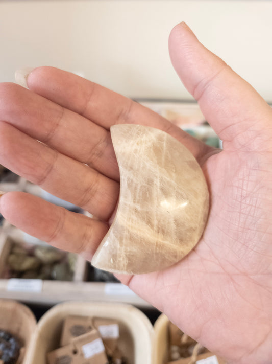 Hand holding a Moon shaped Moonstone