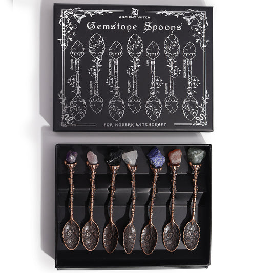 Set of gemstone spoons in a black box with decorative packaging.